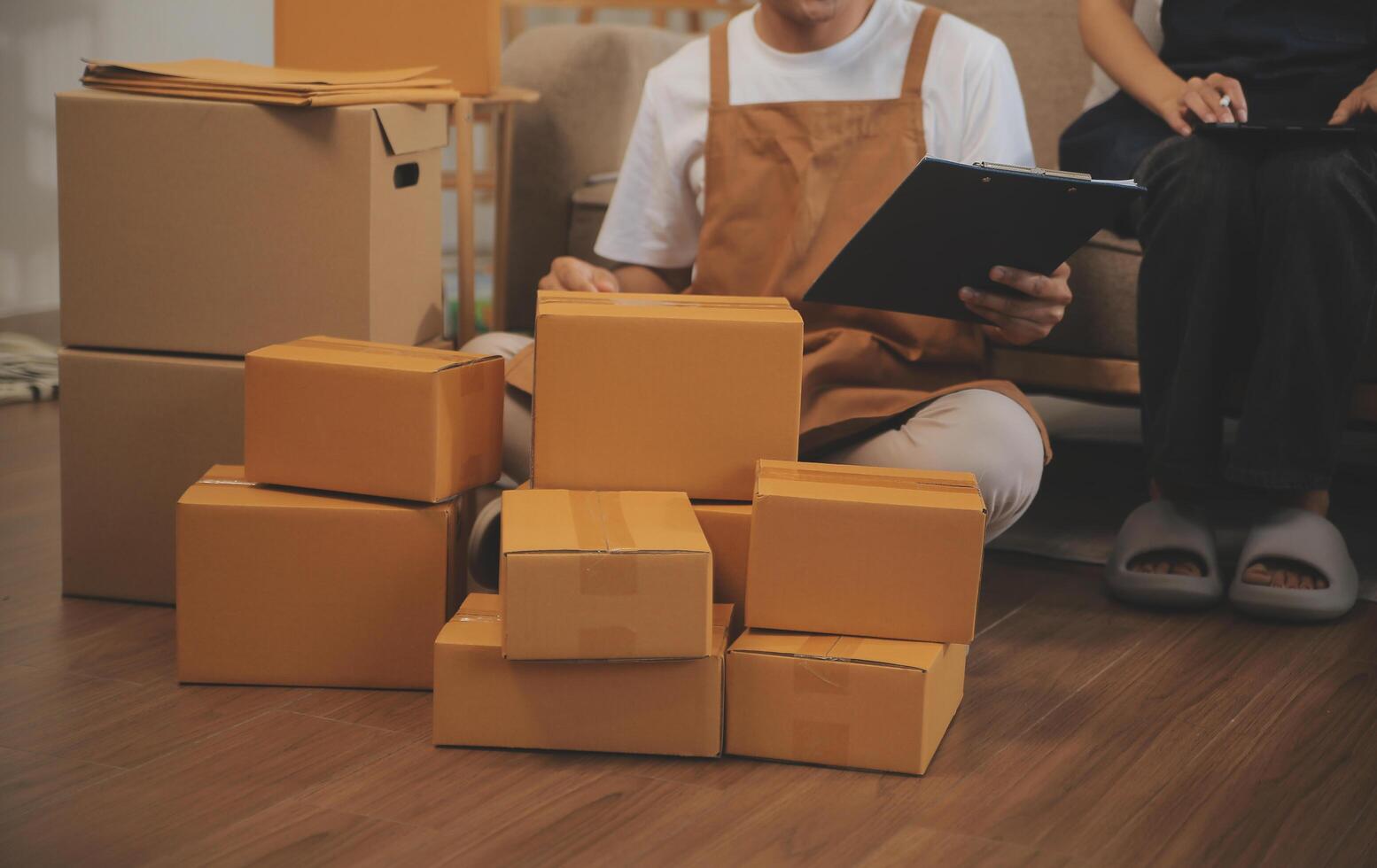 Two Asian blogger showing clothes in front of the camera to recording vlog video live streaming at her shop. Online Shopping Cart notion. on sofa at home photo