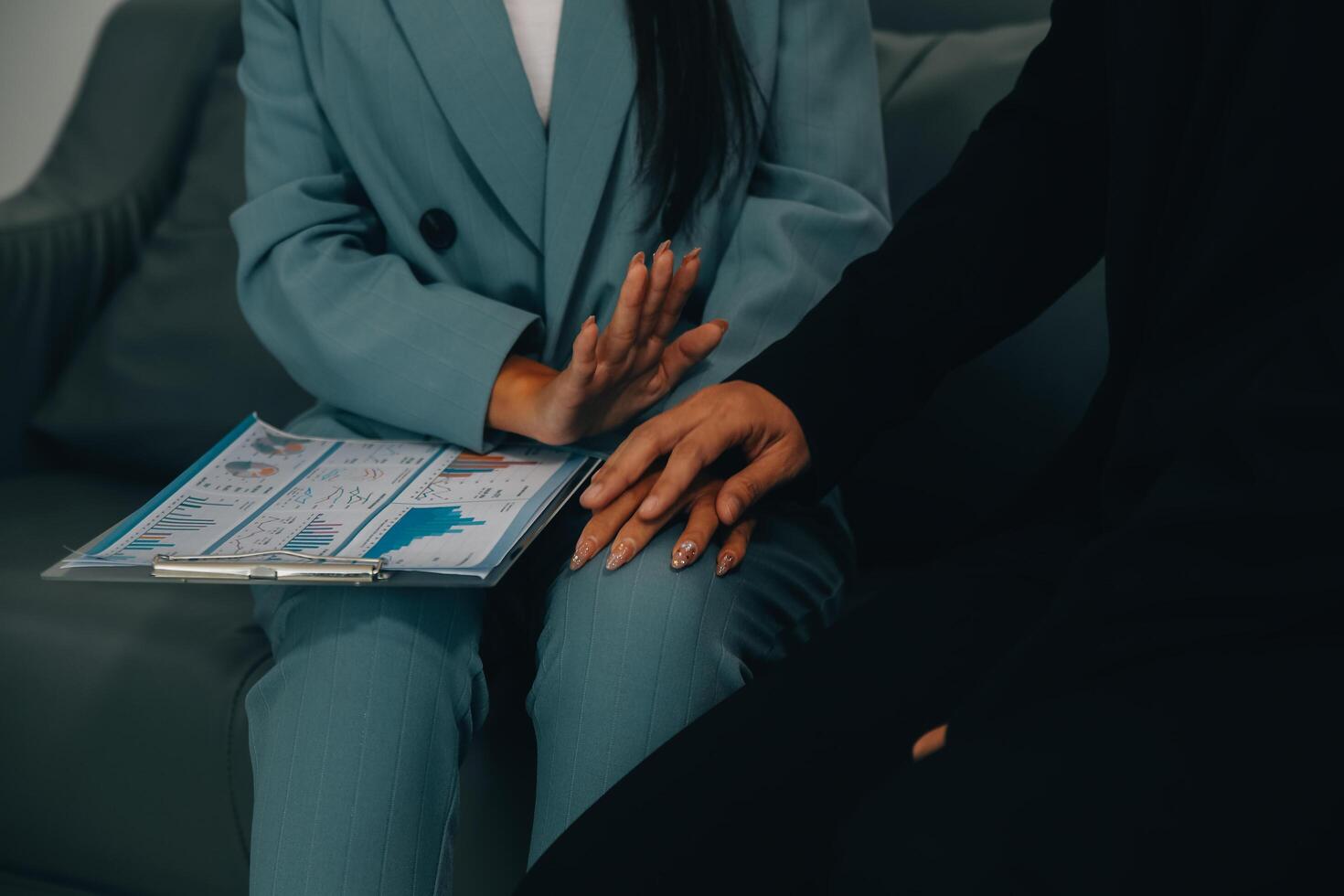 Sexsual harassment in workplace. Unhappy female employee looking at hand of boss touch at her shoulder and feeling disgusted. photo