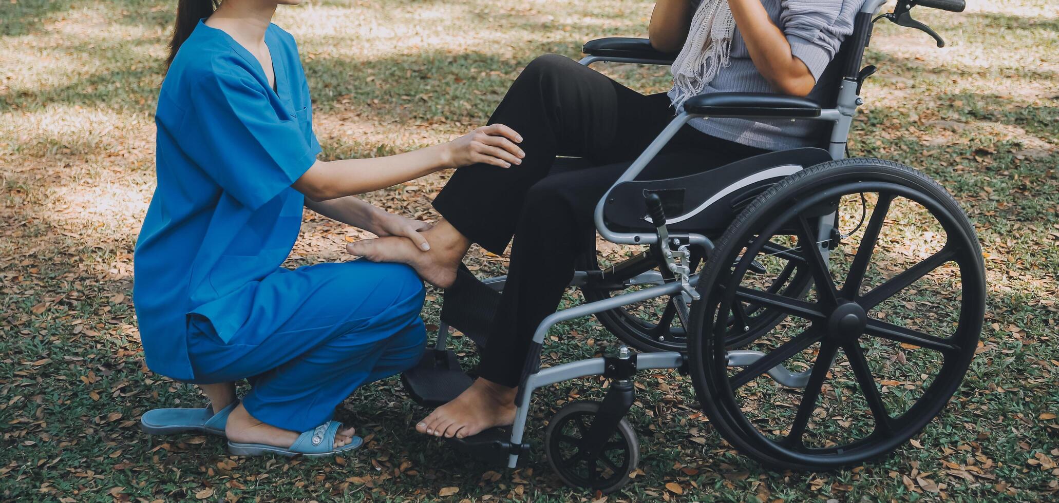 young asian physical therapist working with senior woman on walking with a walker photo