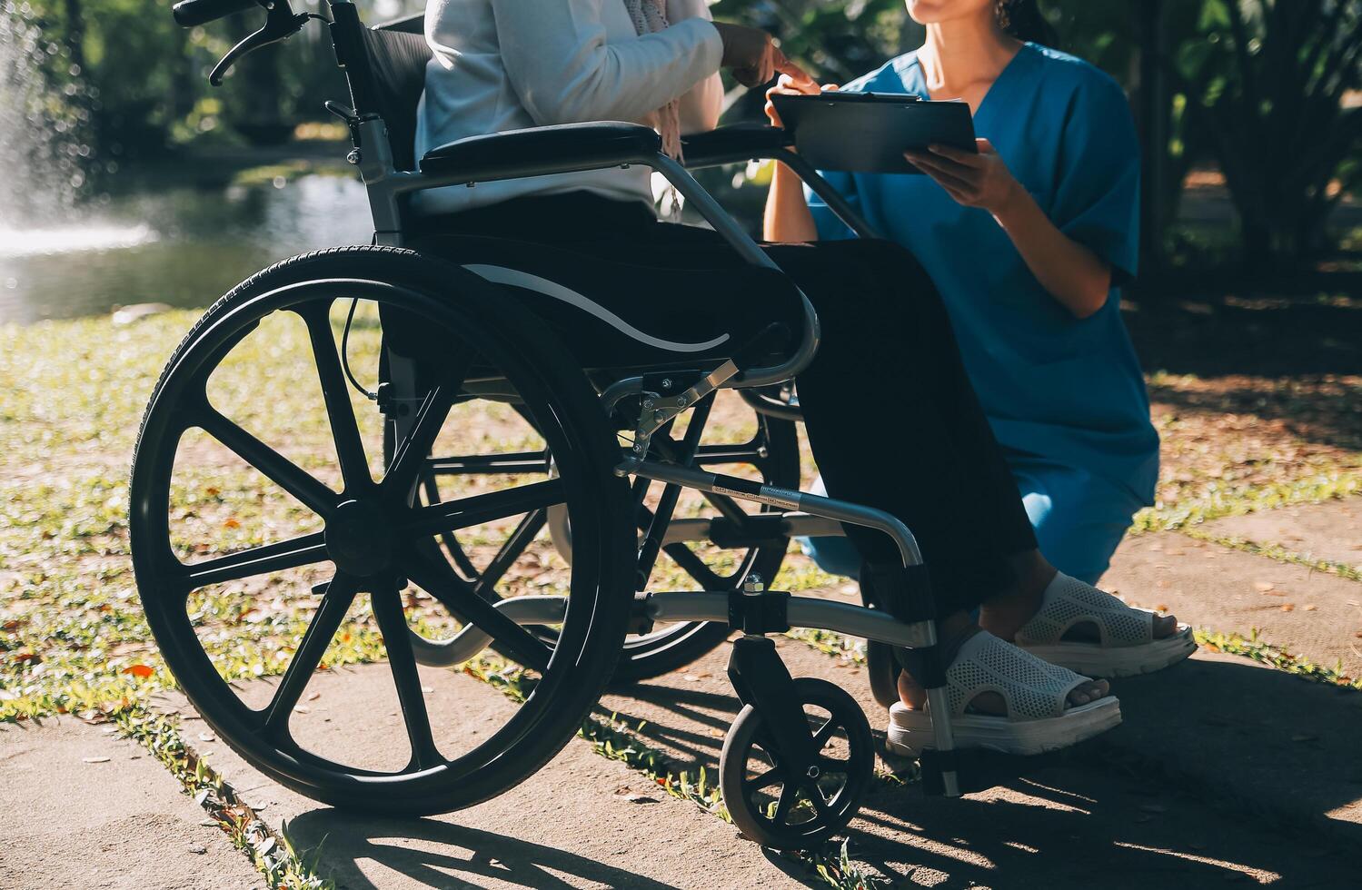 Nursing staff talking to an elderly person sitting in a wheelchair. photo