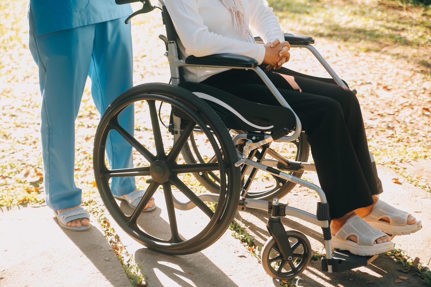 enfermería personal hablando a un mayor persona sentado en un silla de ruedas. foto