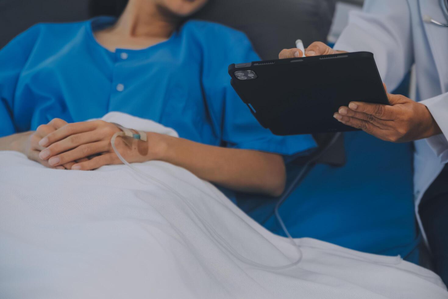 Asian Doctor make routine health check with patient in hospital ward photo