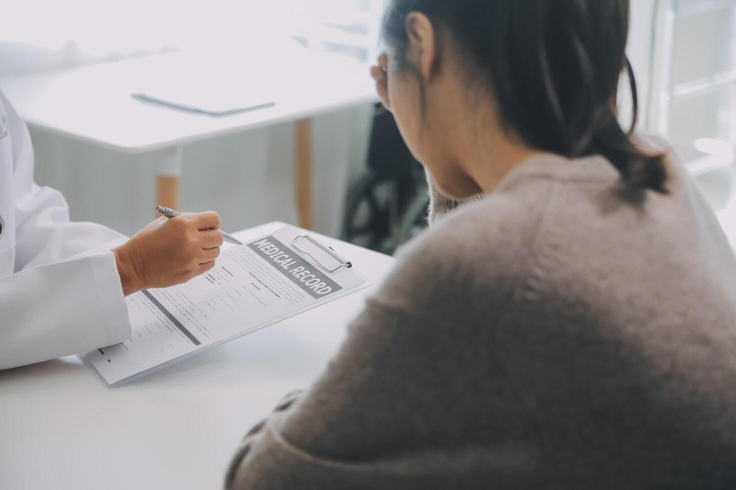 Close up serious doctor wearing medical face mask consulting mature woman patient at appointment in office, physician explaining treatment, giving recommendations, elderly generation healthcare photo