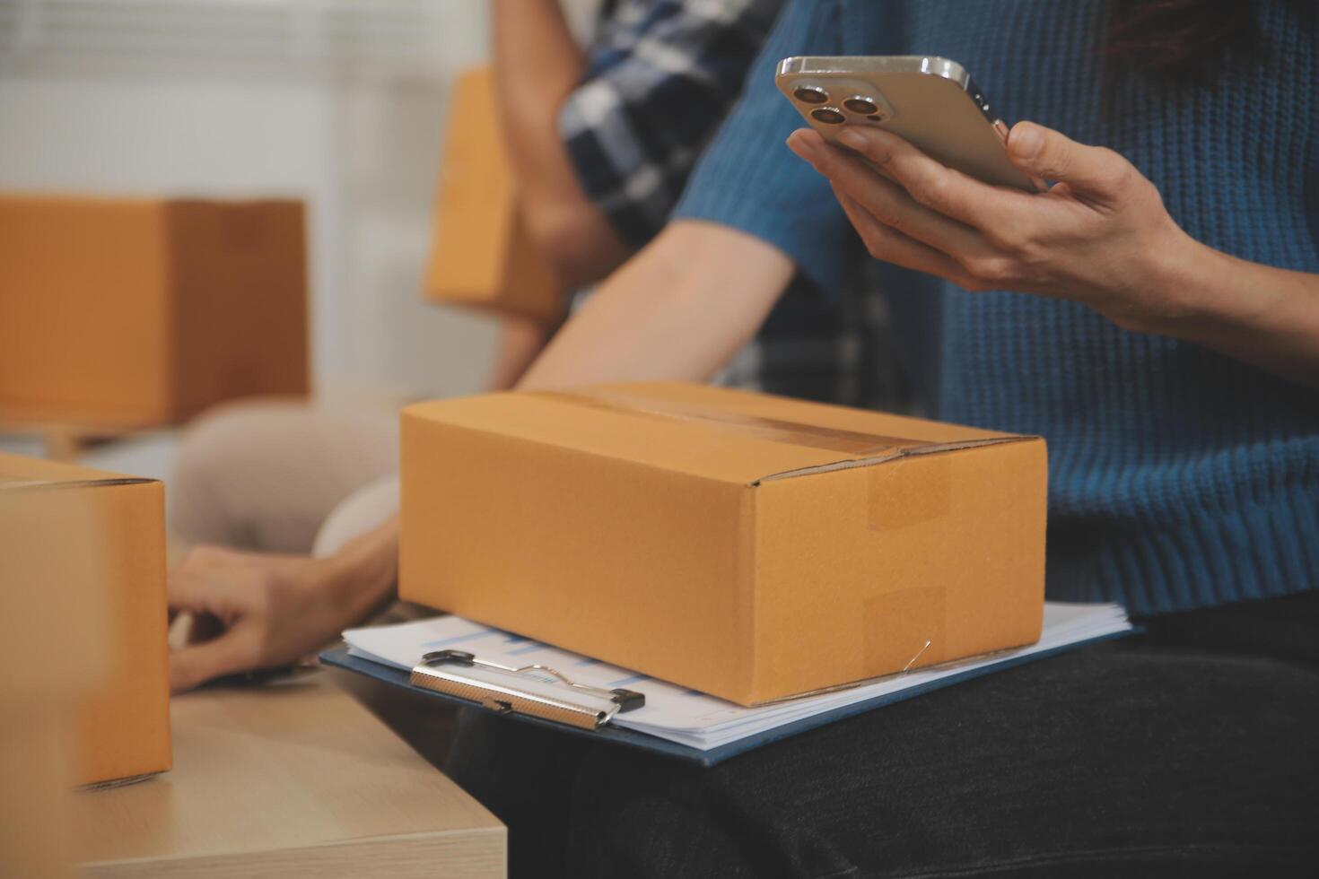 Two Asian blogger showing clothes in front of the camera to recording vlog video live streaming at her shop. Online Shopping Cart notion. on sofa at home photo
