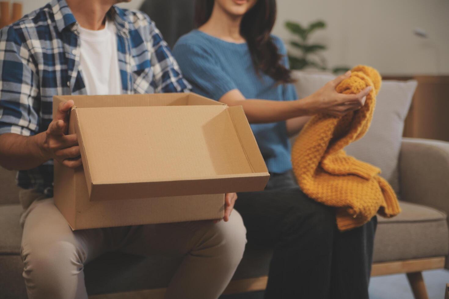 Two Asian blogger showing clothes in front of the camera to recording vlog video live streaming at her shop. Online Shopping Cart notion. on sofa at home photo