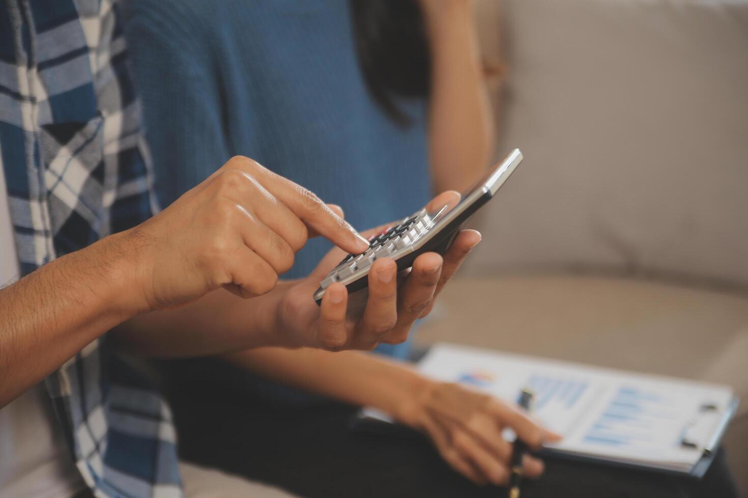 Two Asian blogger showing clothes in front of the camera to recording vlog video live streaming at her shop. Online Shopping Cart notion. on sofa at home photo