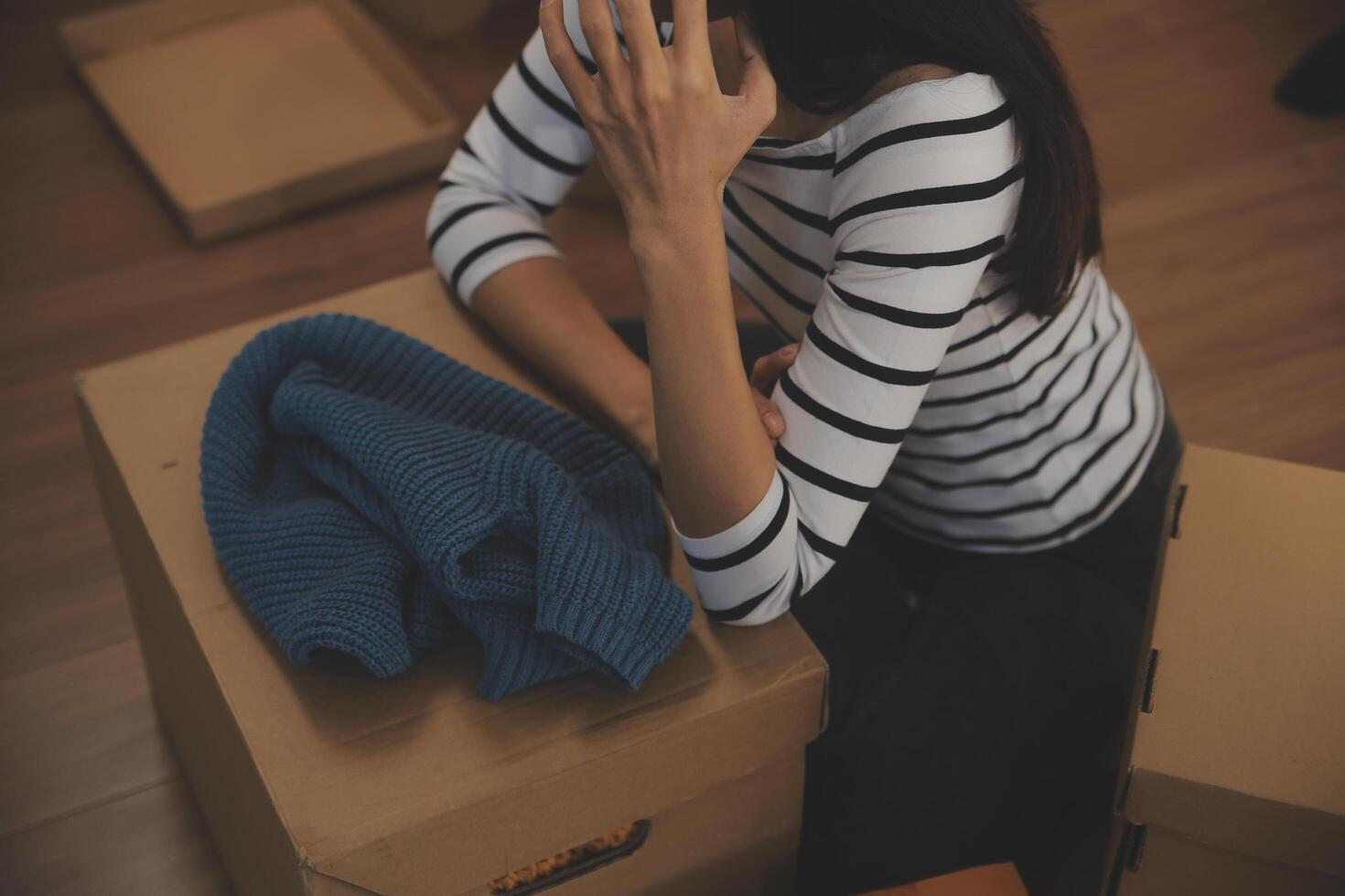 Two Asian blogger showing clothes in front of the camera to recording vlog video live streaming at her shop. Online Shopping Cart notion. on sofa at home photo