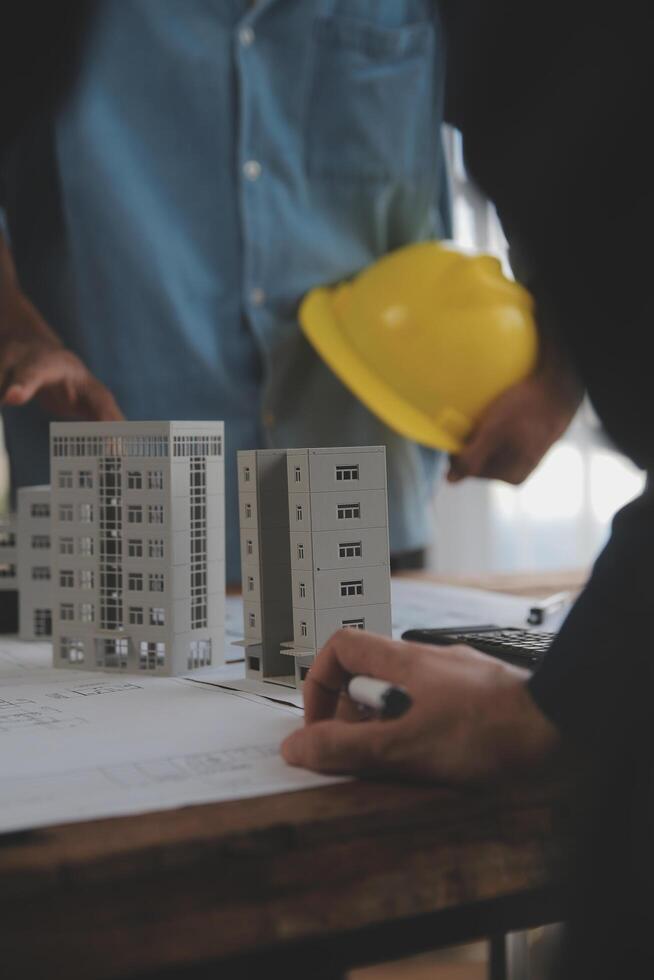 Construction and structure concept of Engineer or architect meeting for project working with partner and engineering tools on model building and blueprint in working site, contract for both companies. photo