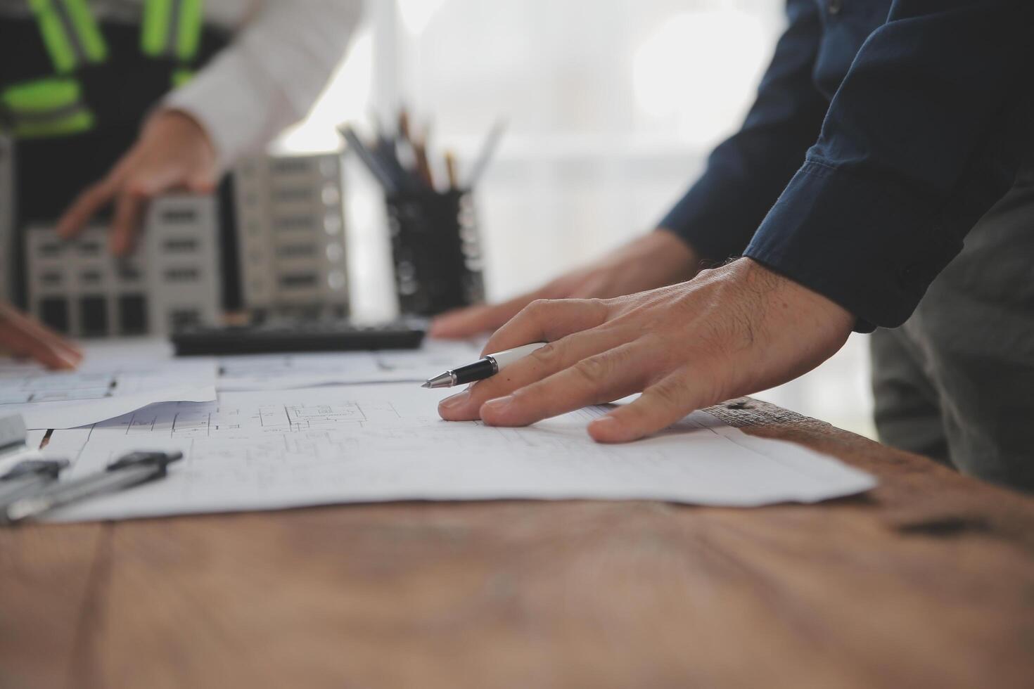 concepto de construcción y estructura de reunión de ingenieros o arquitectos para el proyecto que trabaja con socios y herramientas de ingeniería en la construcción de modelos y planos en el lugar de trabajo, contrato para ambas empresas. foto