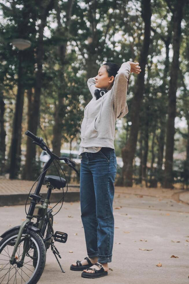 Happy Asian young woman walk and ride bicycle in park, street city her smiling using bike of transportation, ECO friendly, People lifestyle concept. photo