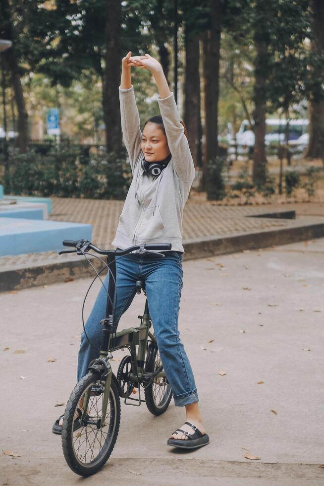 Happy Asian young woman walk and ride bicycle in park, street city her smiling using bike of transportation, ECO friendly, People lifestyle concept. photo