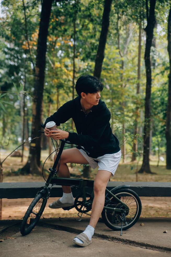 hermoso contento joven hombre con bicicleta en un ciudad calle, activo estilo de vida, personas concepto foto