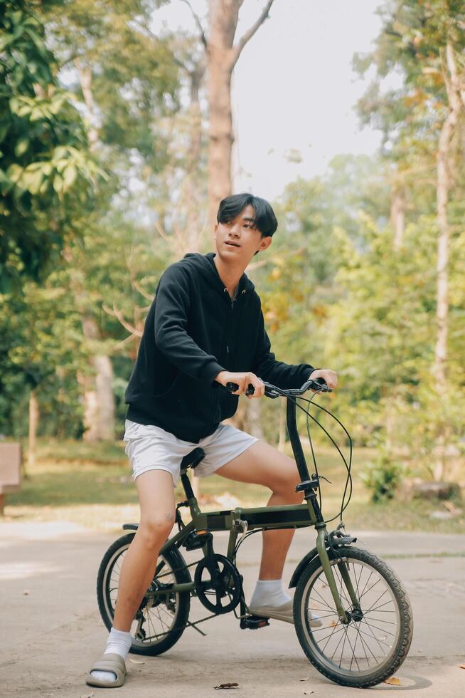 hermoso contento joven hombre con bicicleta en un ciudad calle, activo estilo de vida, personas concepto foto