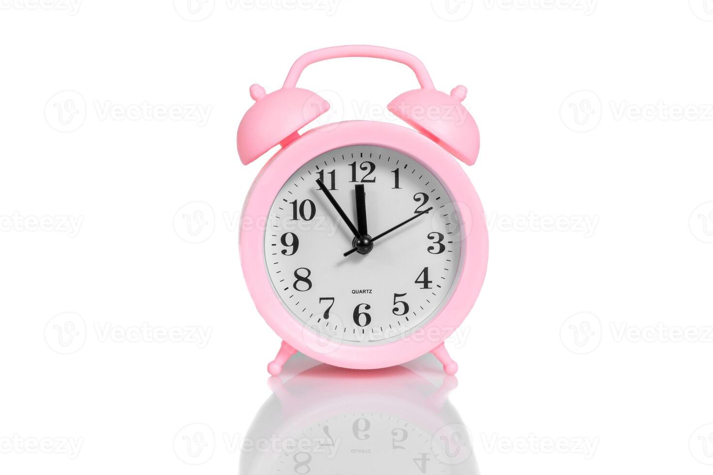 pink alarm clock set twelve o'clock isolated over white background photo