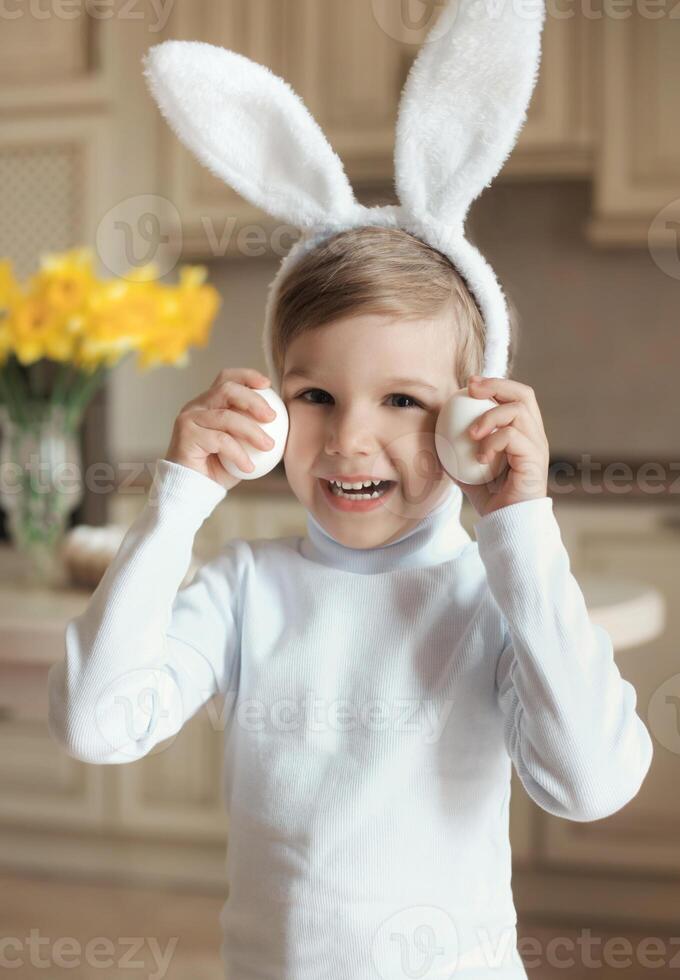 Vertical portrait of happy little boy in bunny costume, holding to spring easter holiday photo