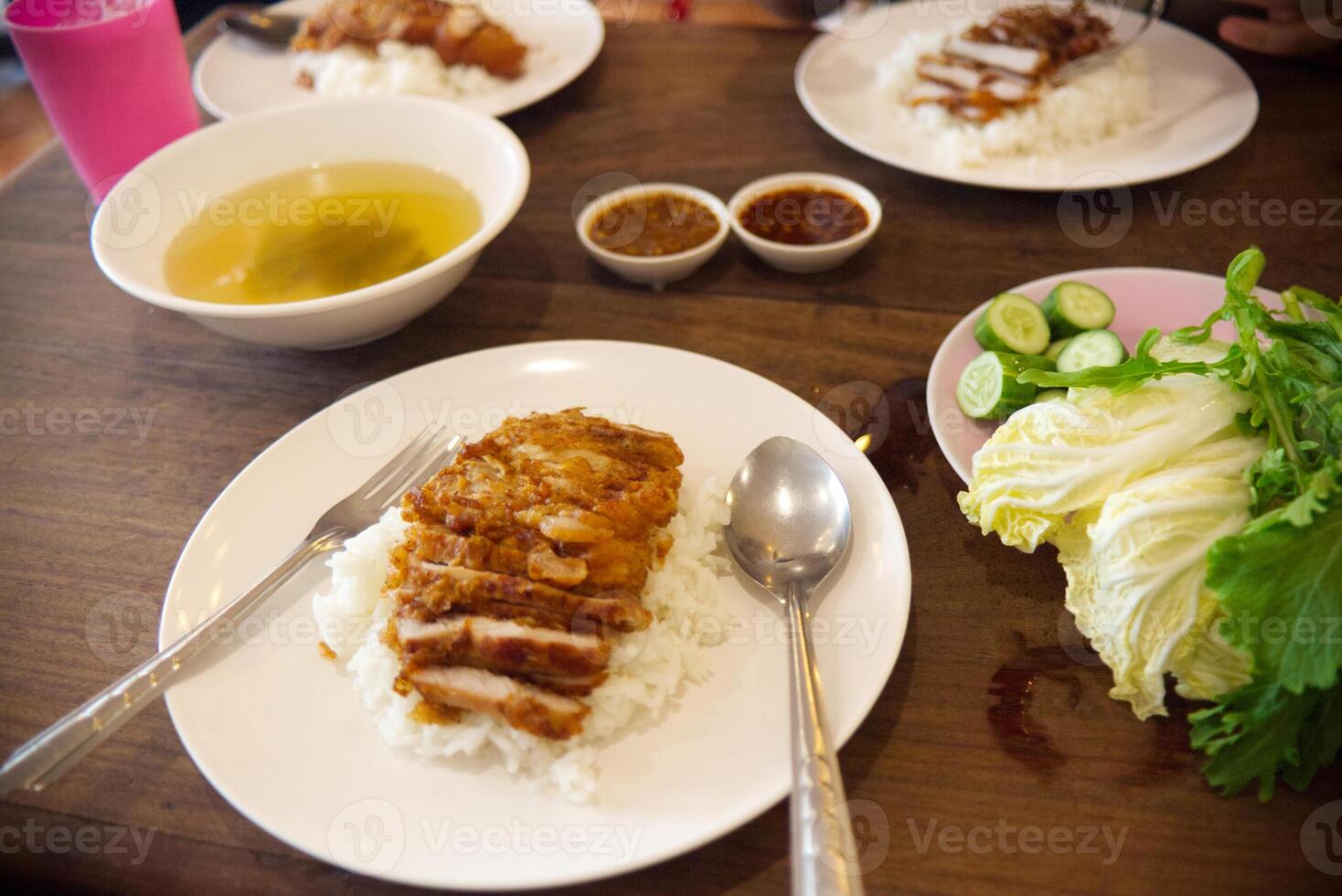 thai fry pork on rice serve with soup and sauce and fresh vegetable photo