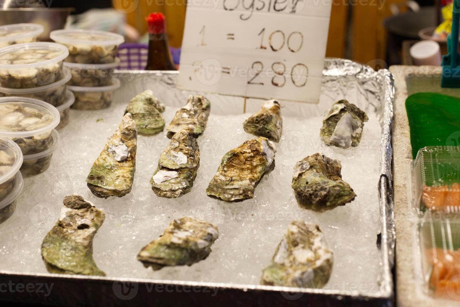 Fresh oysters seafood on ice selling in a market photo