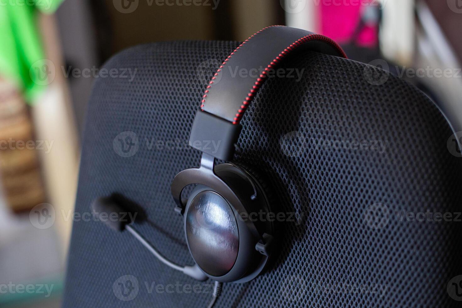 black headset on backrest of empty computer chair with air mesh upholstery photo