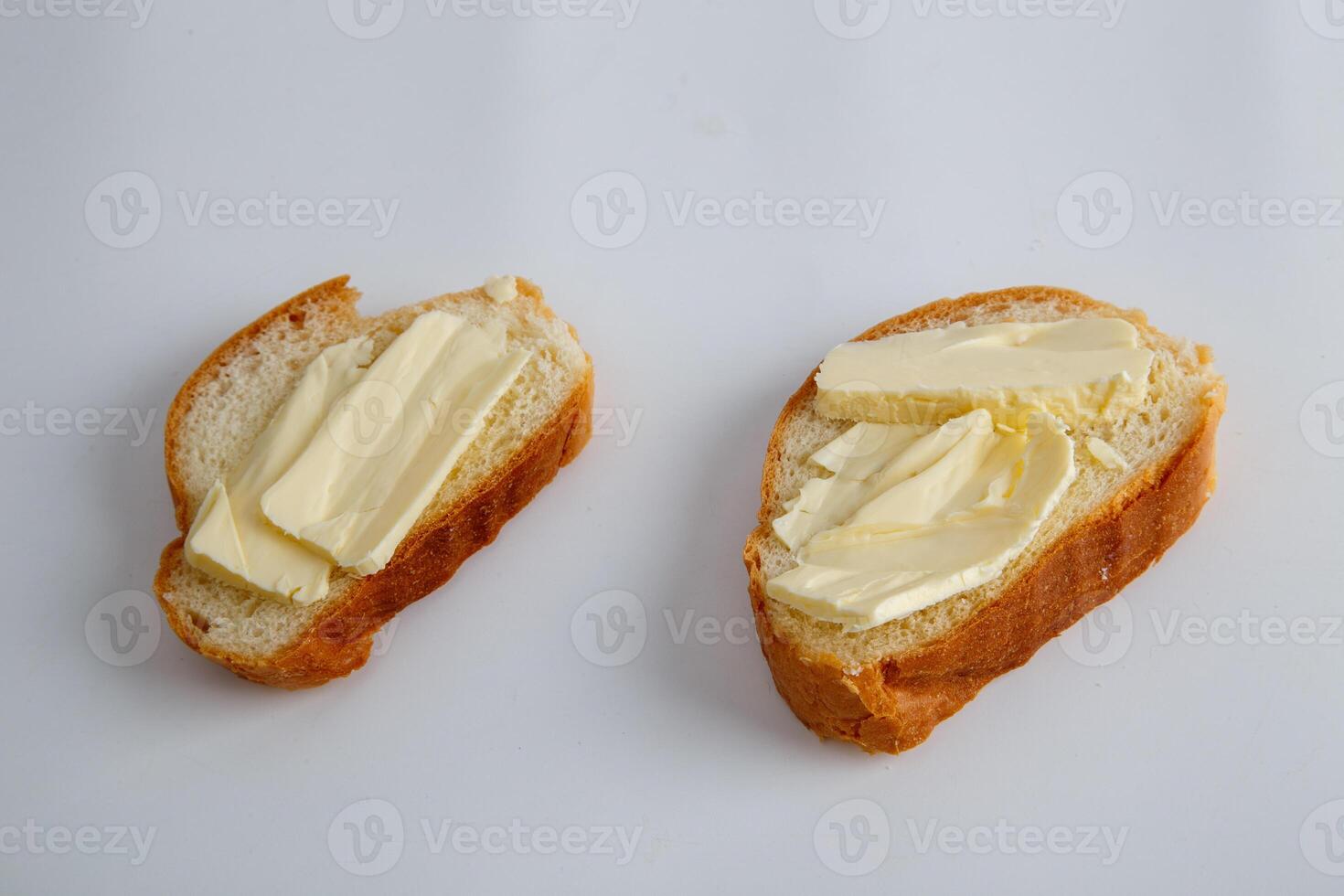two pieces of white bread with butter on white background photo