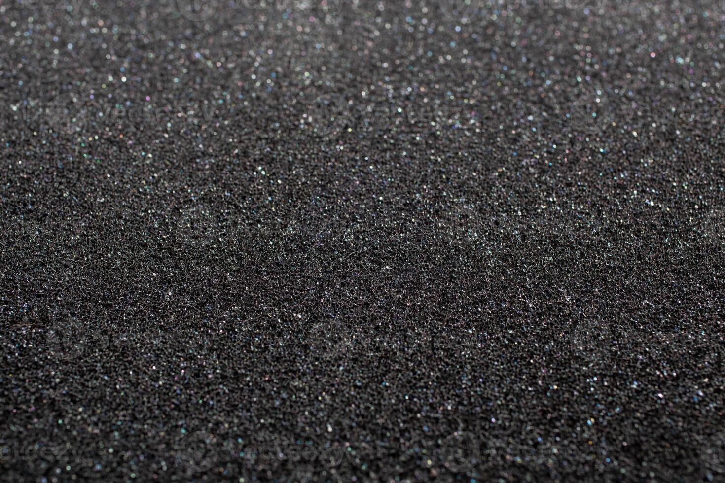 Black foam rubber. Closeup full-frame macro background with selective focus and shallow depth of field. photo