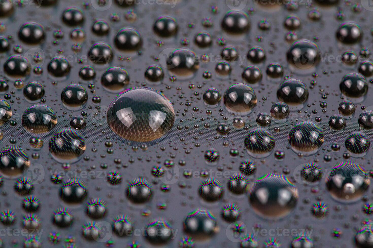 water drops on surface of screen of cellphone, close-up with selective focus and blur photo