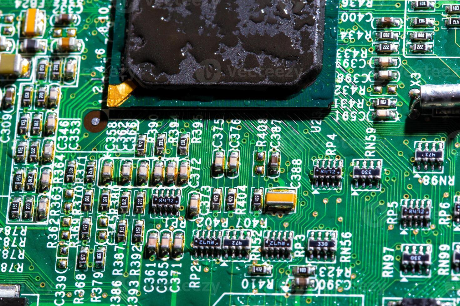 wet digital circuit board with microprocessors and components, closeup full-frame macro background photo