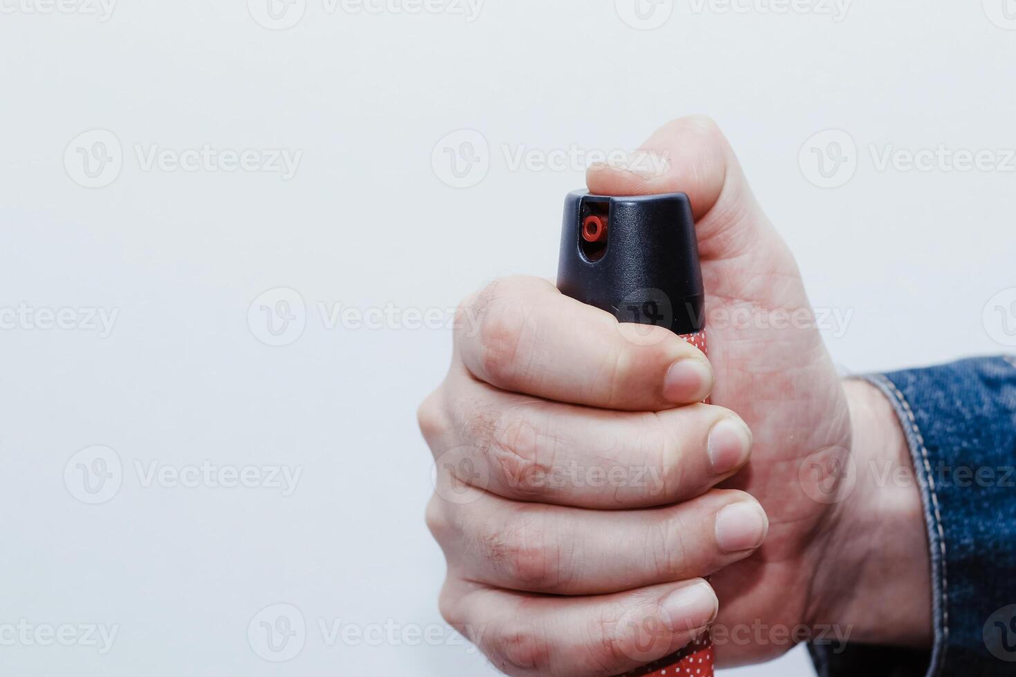 A man presses a pepper spray, the concept of robbery, danger or protection photo