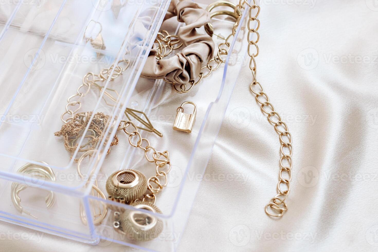 Gold jewelry earrings bracelets in a transparent organizer photo