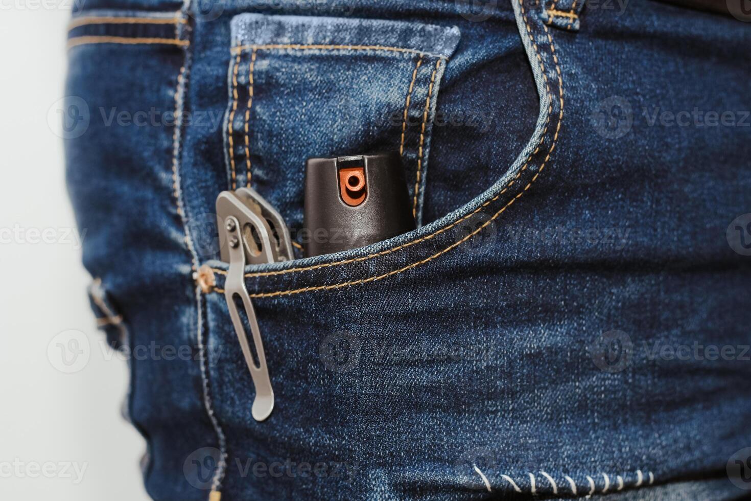 un cuchillo y un gas frasco en el bolsillo de vaqueros, el concepto de cada día llevar foto