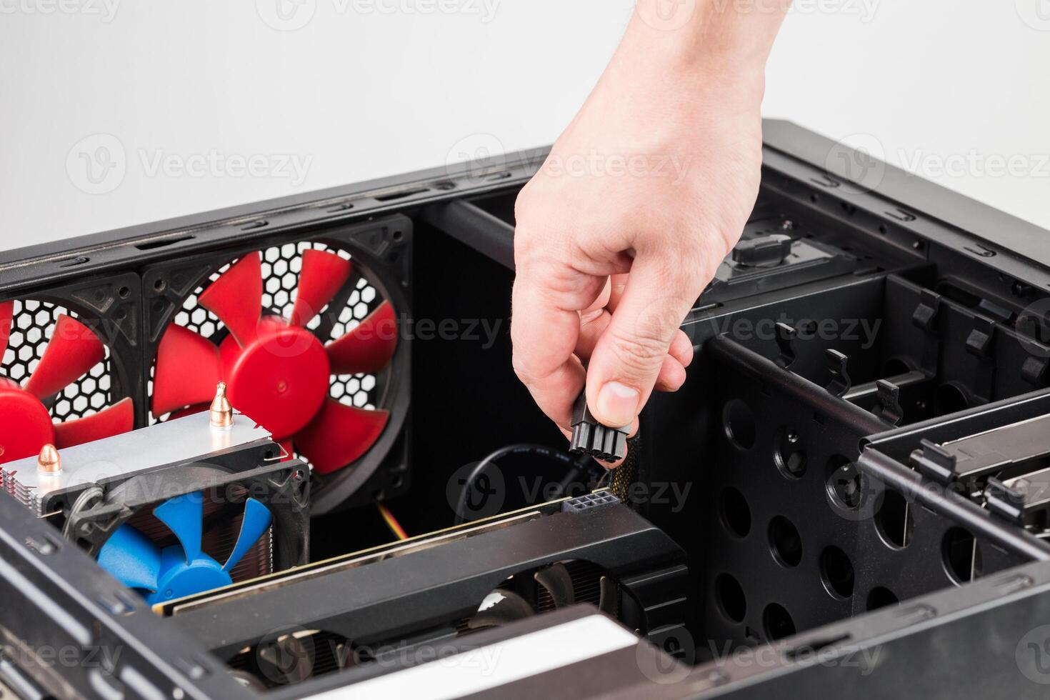 hand connecting or disconnecting power connector of GPU card in PC case photo