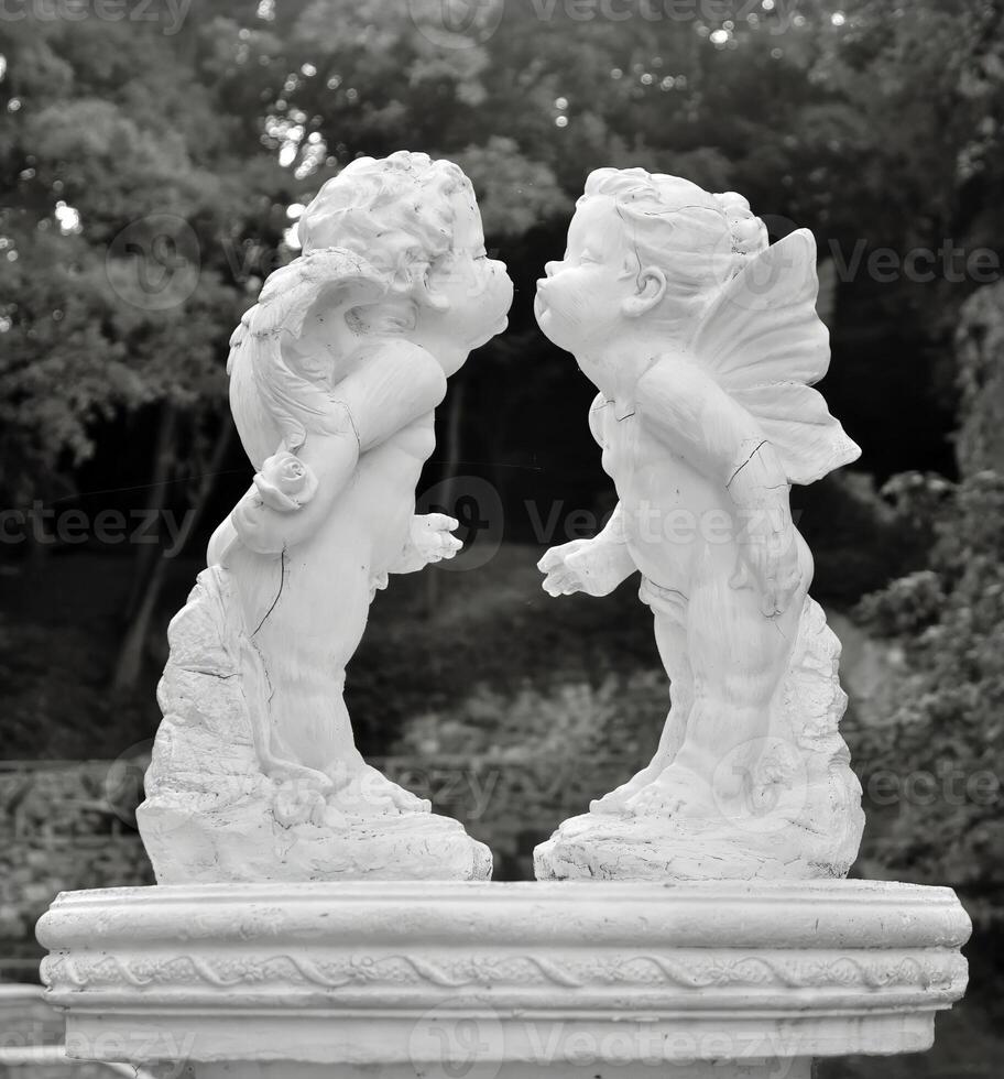 Two statues of cherubs kissing in a fountain photo