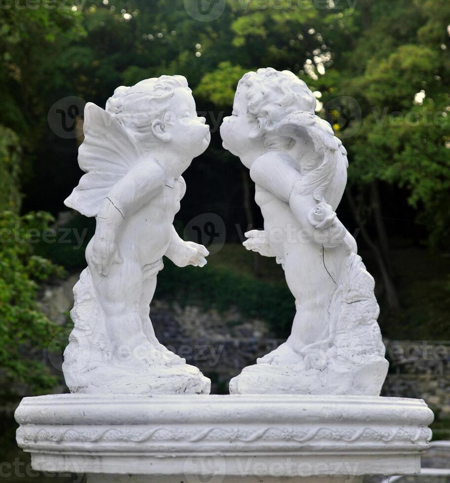 Two statues of cherubs kissing photo