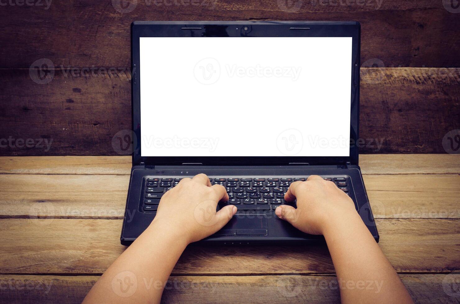 hands typing on laptop on wooden background photo