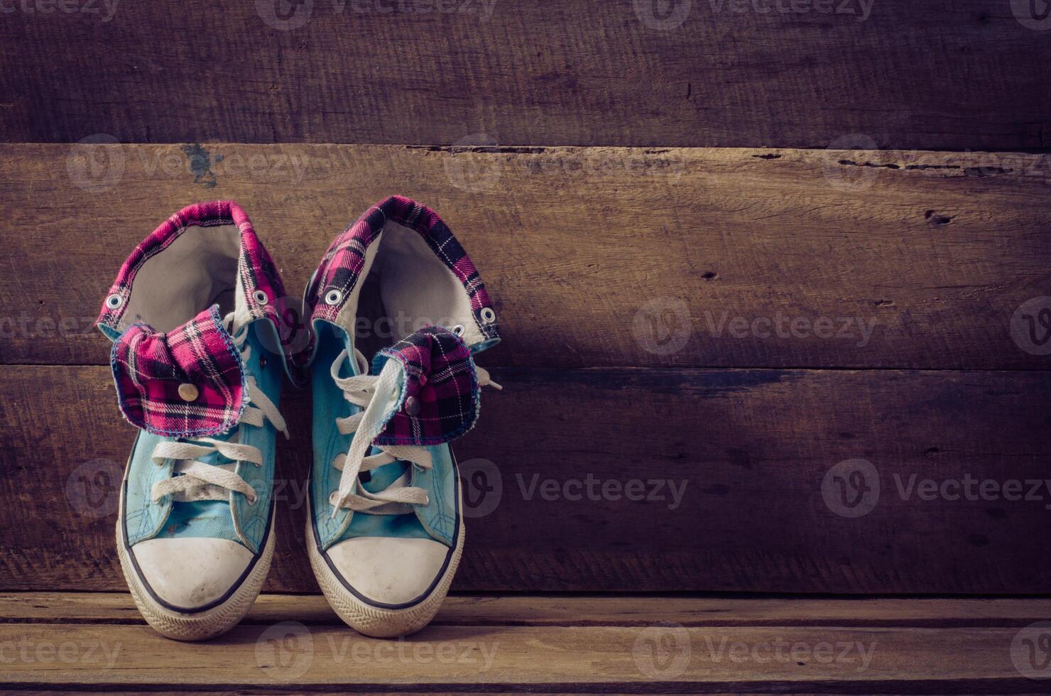Sneakers on floor on wooden background photo