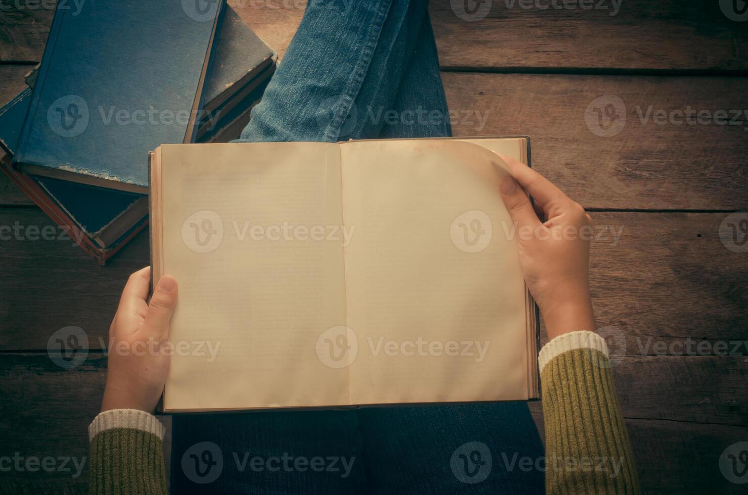reading book on wooden floor with book - tone vintage photo