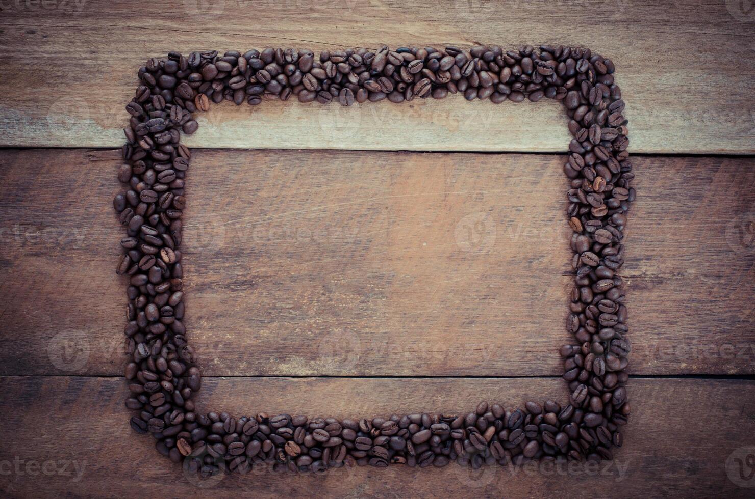 Rectangle frame made of coffee beans on the wooden background photo
