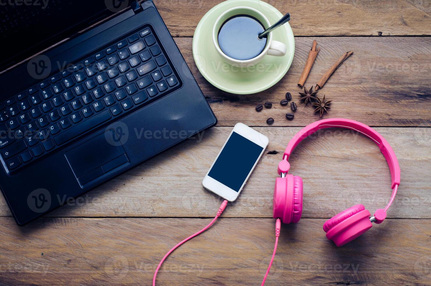 Coffee cup, notebook, headphone and smart phone on the wooden floor in the morning. photo