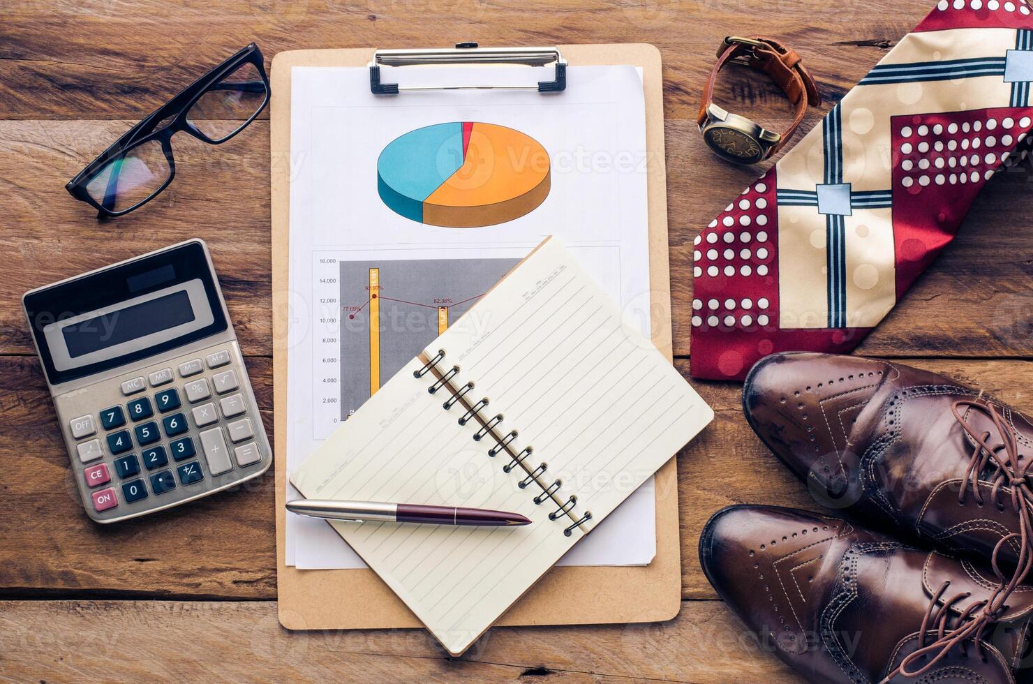 costume calculator, pen, notebook and accessory for work on wooden table. photo