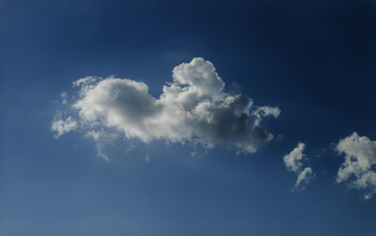A blue sky with clouds flying photo