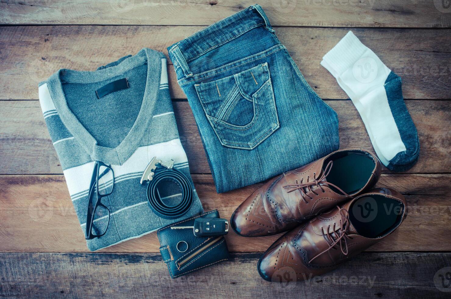 Sweaters, jeans, socks, shoes, belts, wallets, sunglasses, ready for travel. photo