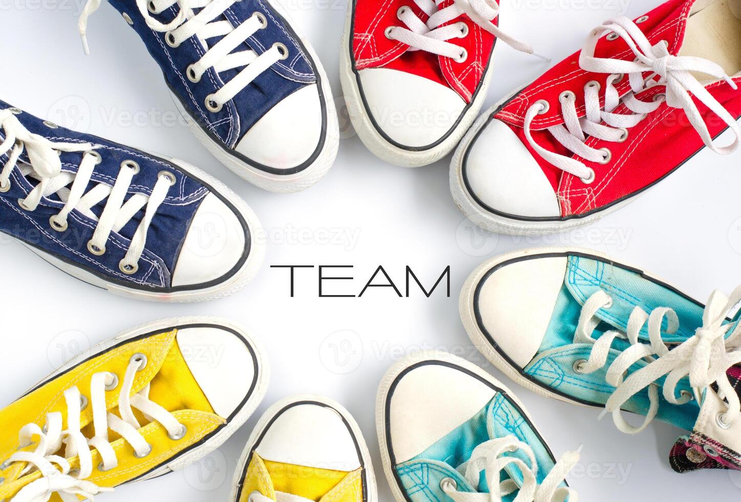 Multicolored sneakers on white background and word  TEAM concept team work photo