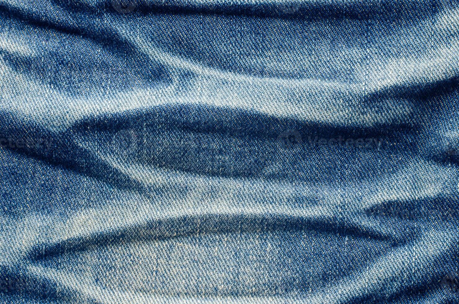 Wrinkles blue jeans texture. Jeans background. photo