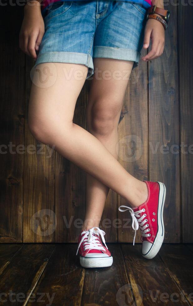 Adolescente en pie poses atención pierna foto