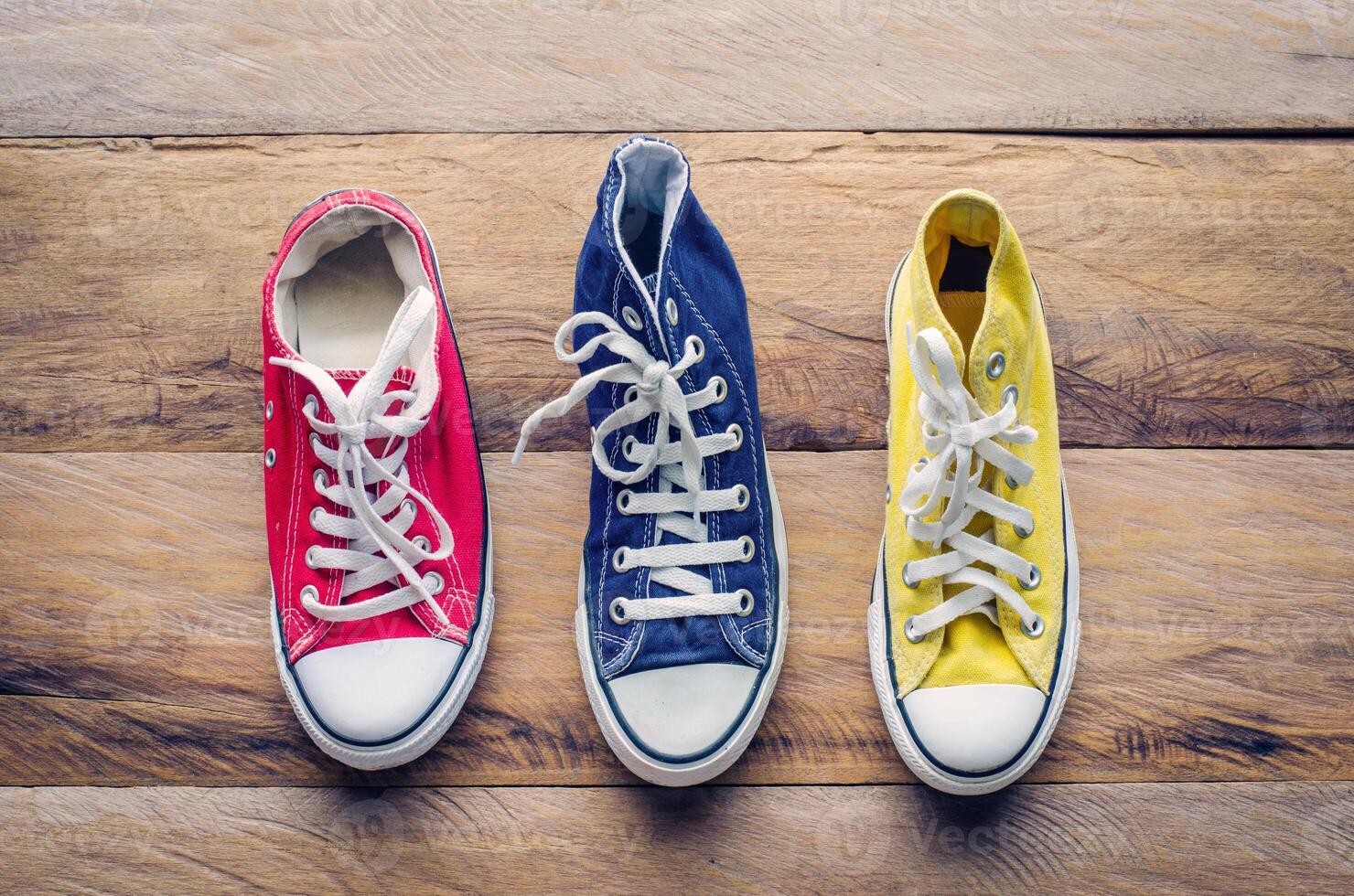 Multicolored sneakers on wooden floor photo