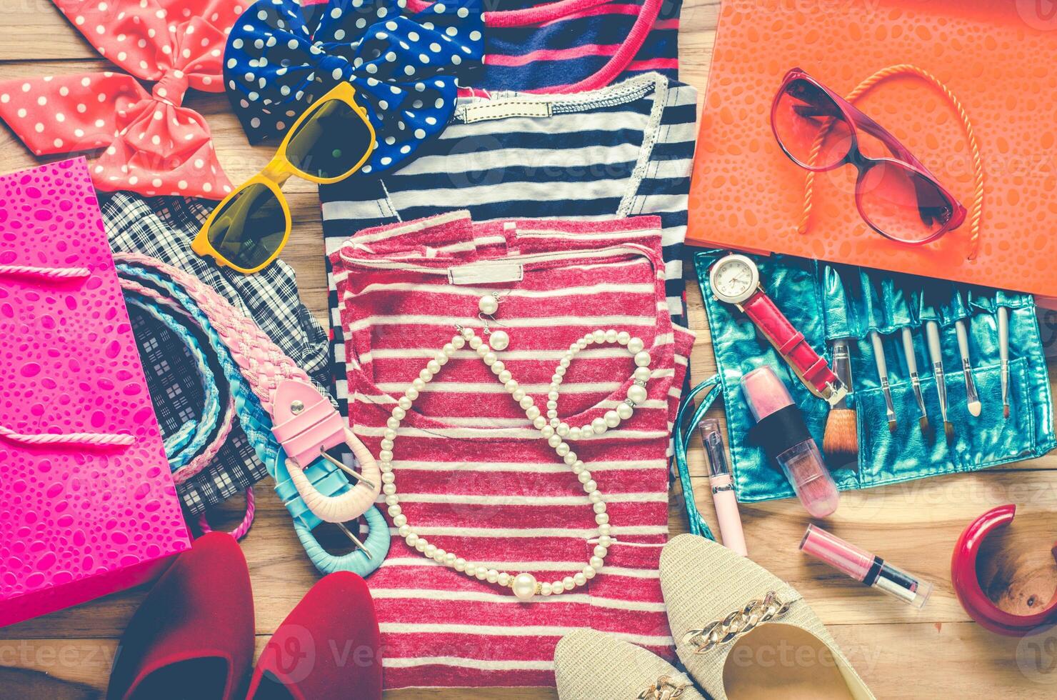 Colorful clothes and accessories to dress arranged on a wooden table. photo