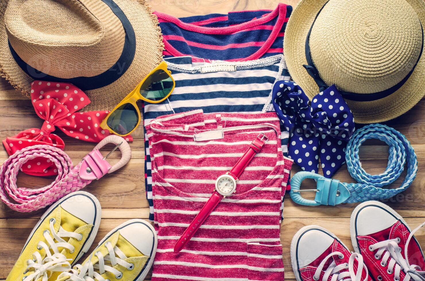 Colorful clothes and accessories to dress arranged on a wooden table. photo