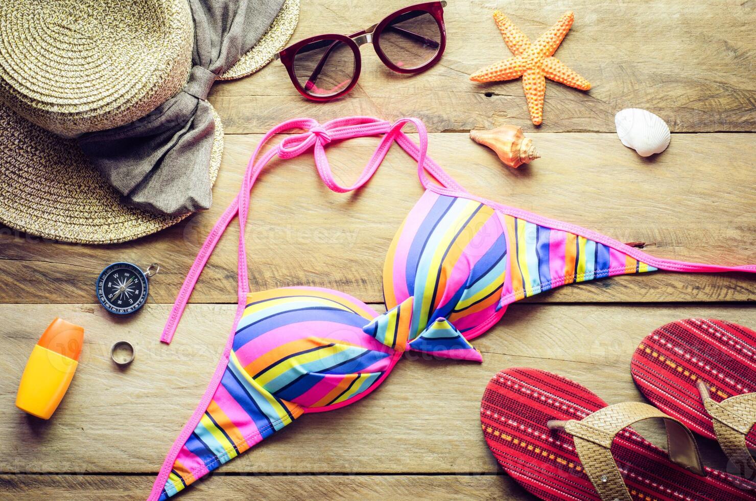 Beauty colorful bikini and accessories on wooden floor for trip on summer photo