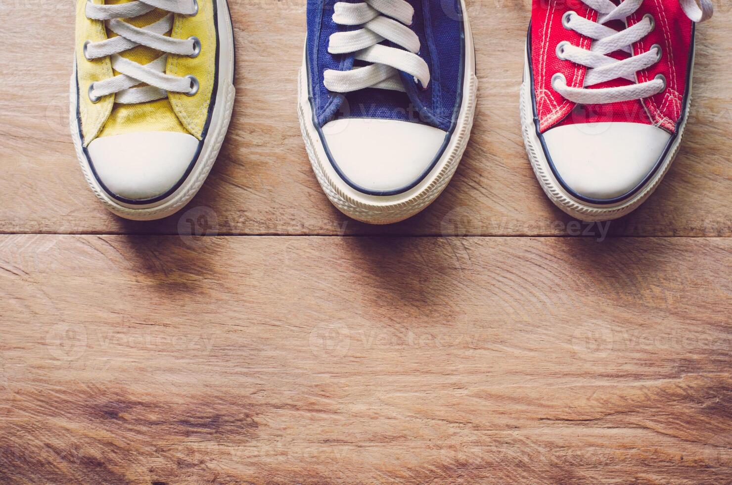 Multi Color sneakers on wood background photo