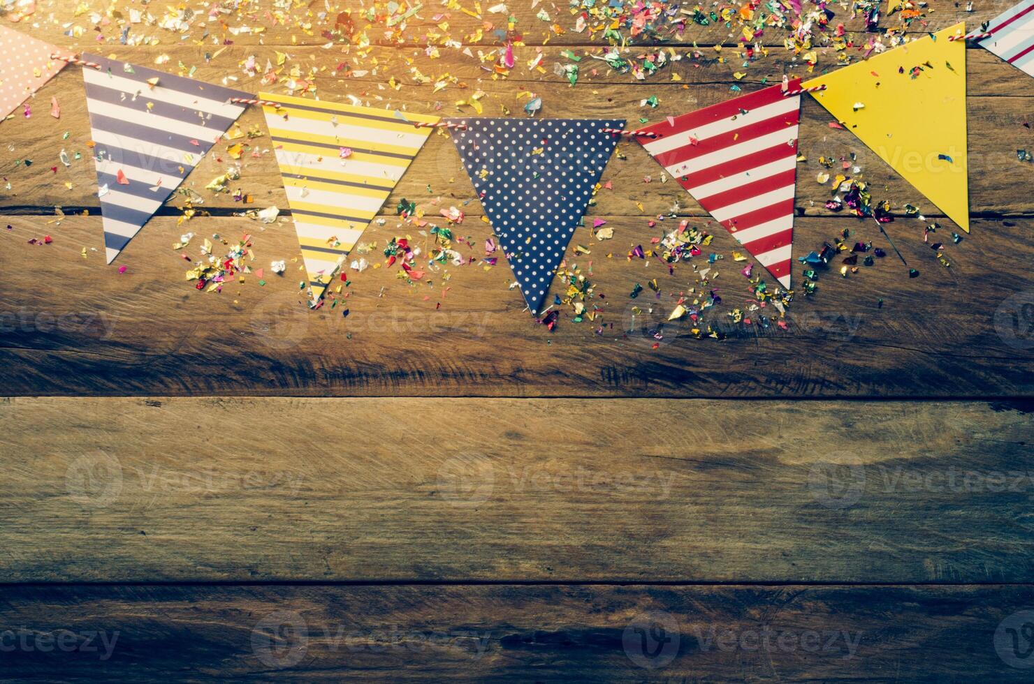 The colorful flag line decorating the banquet has wooden floor as background. photo