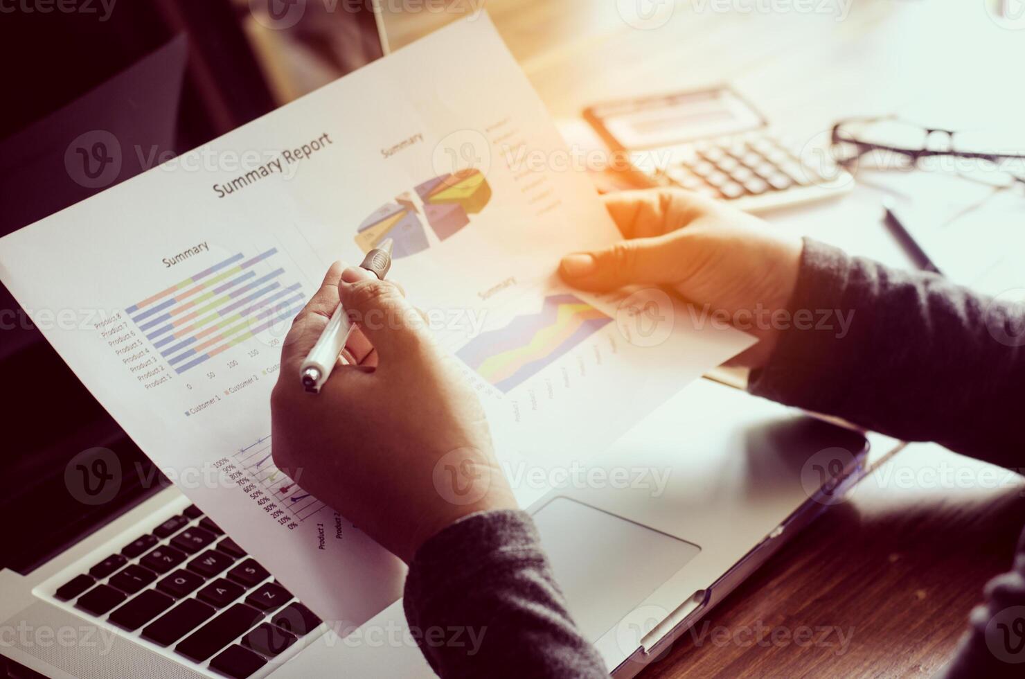 Businessman holding paperwork on the table and analyzing investment chart working in office. Business work concept. photo